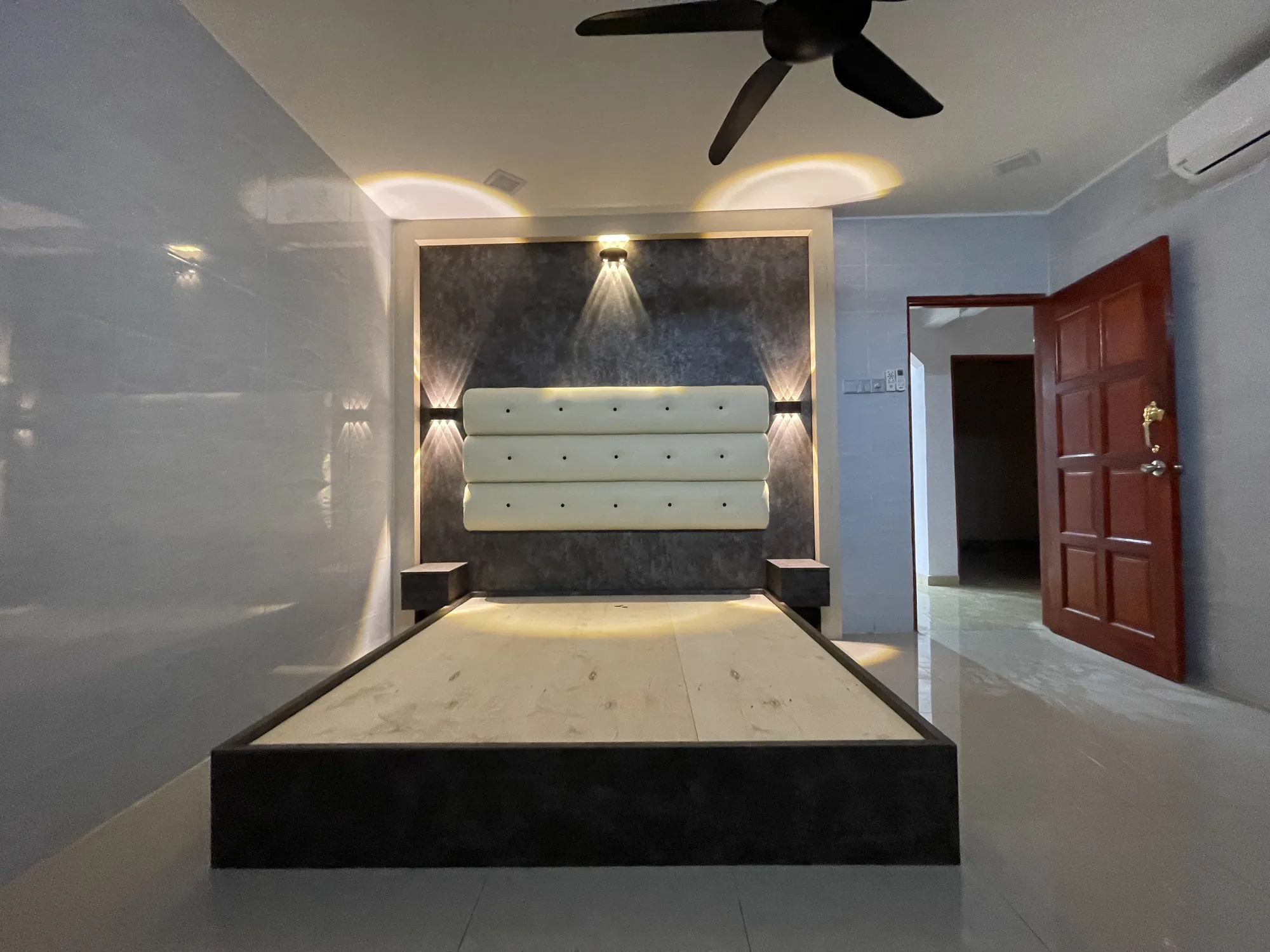 Custom bed divan with upholstered panels and warm architectural lighting