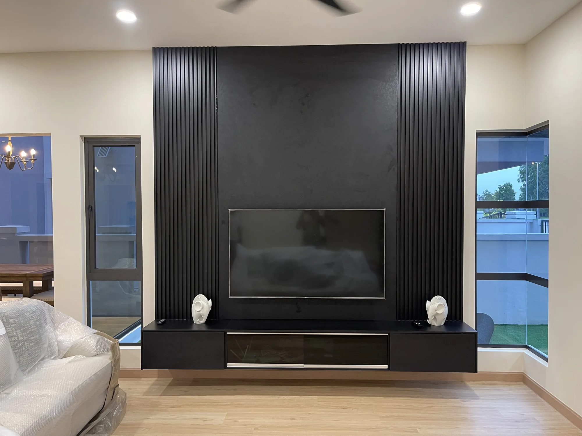 Minimal black TV feature wall with fluted panels and floating console